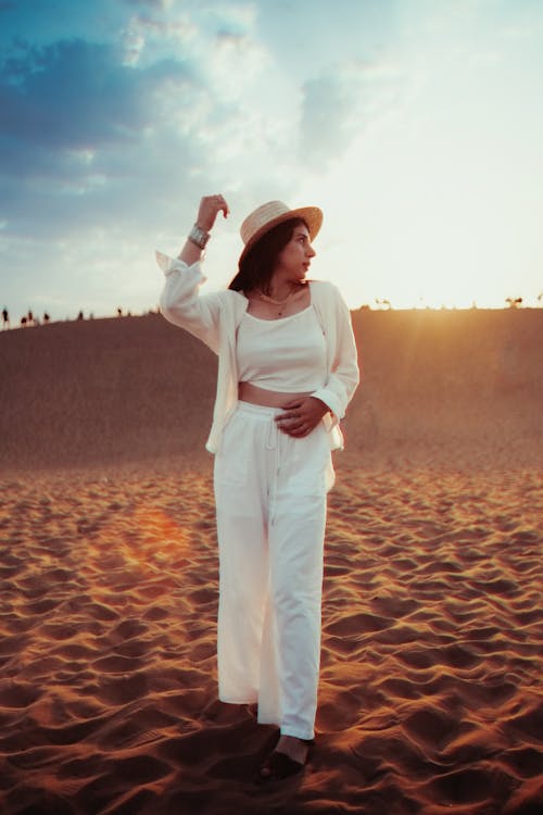 Free A woman in white standing on a sand dune Stock Photo
