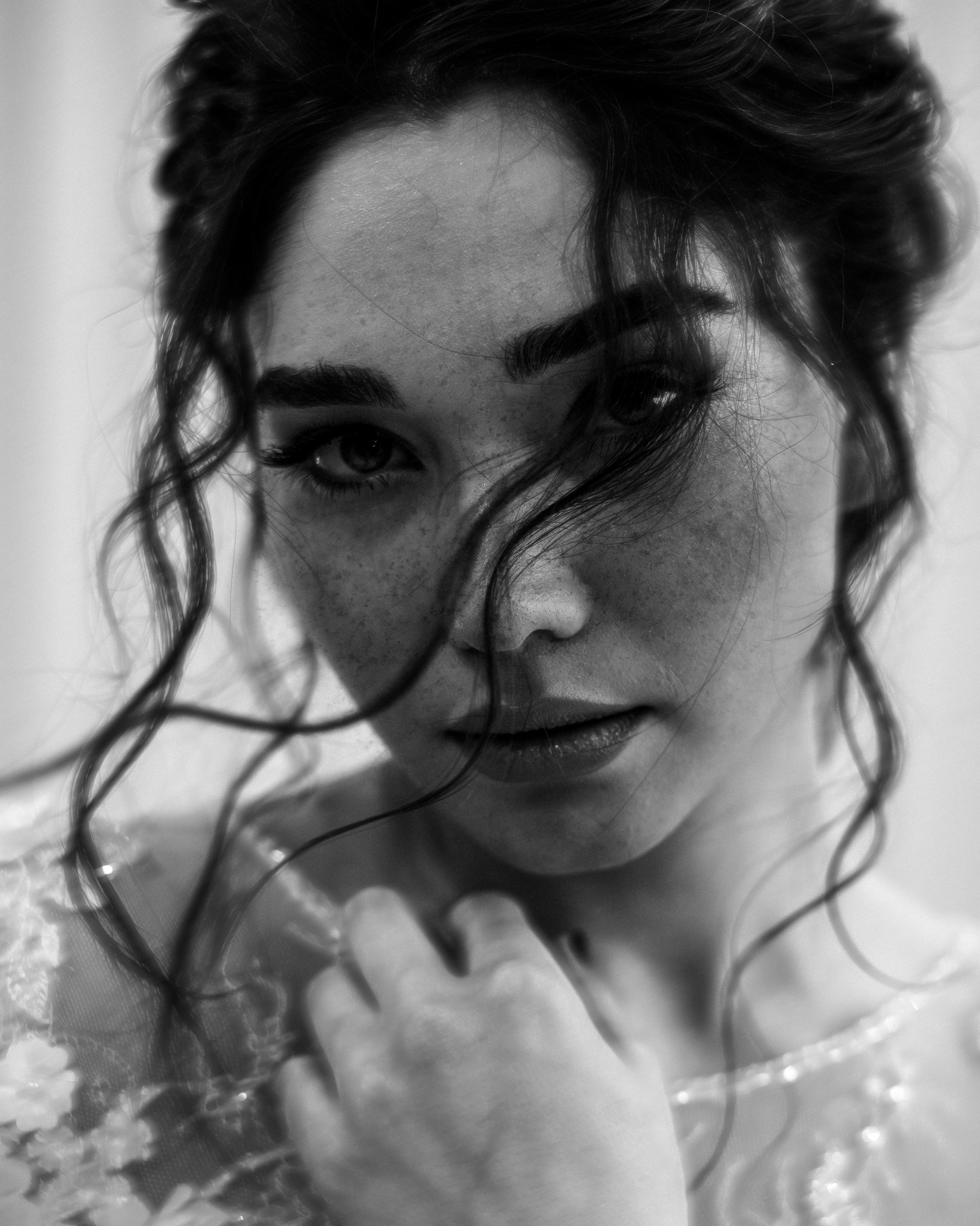 Elegant black and white portrait capturing the expressive gaze of a young woman.