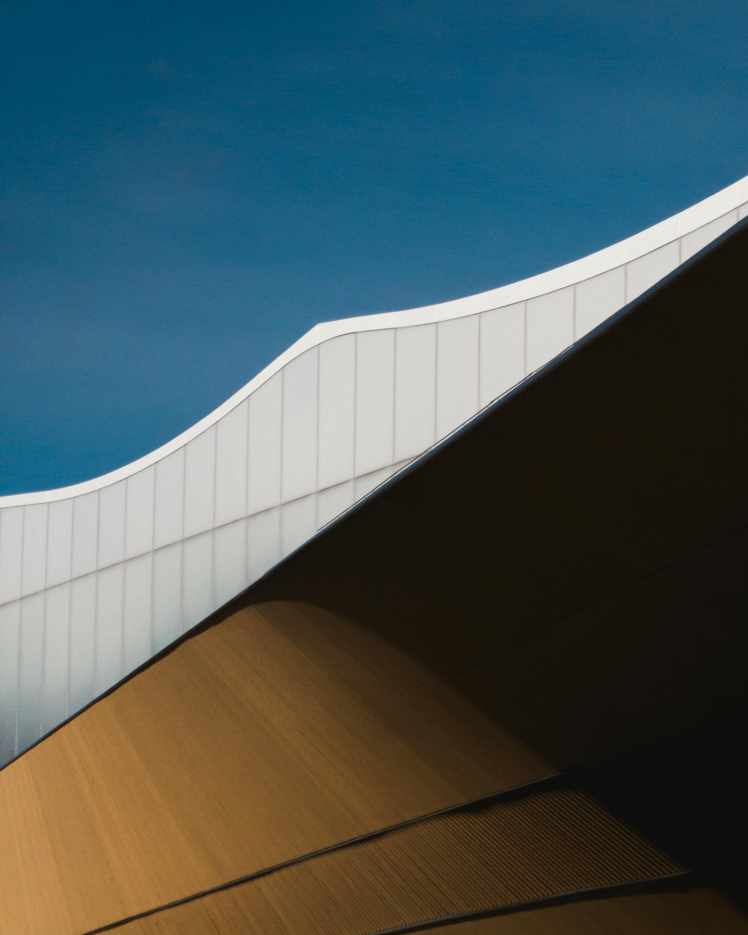 Striking angular facade of a modern building in Helsinki under a clear blue sky.