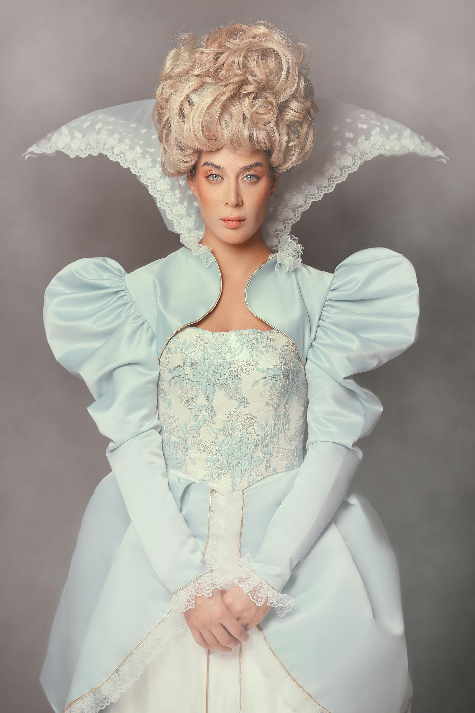 Regal woman in vintage costume posing elegantly in studio setting.