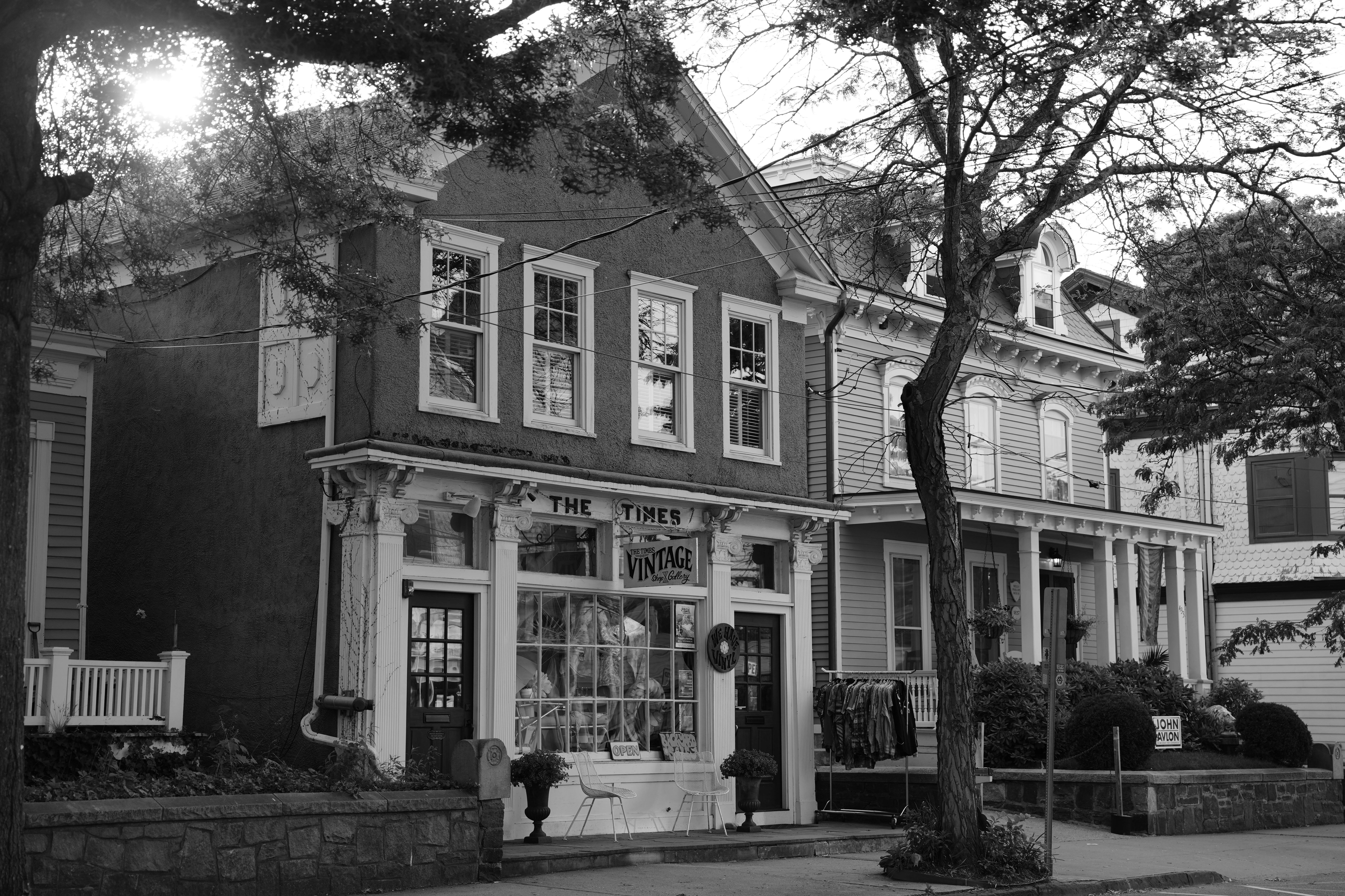 Quaint vintage shop facade in a historic town setting, captured in black and white.