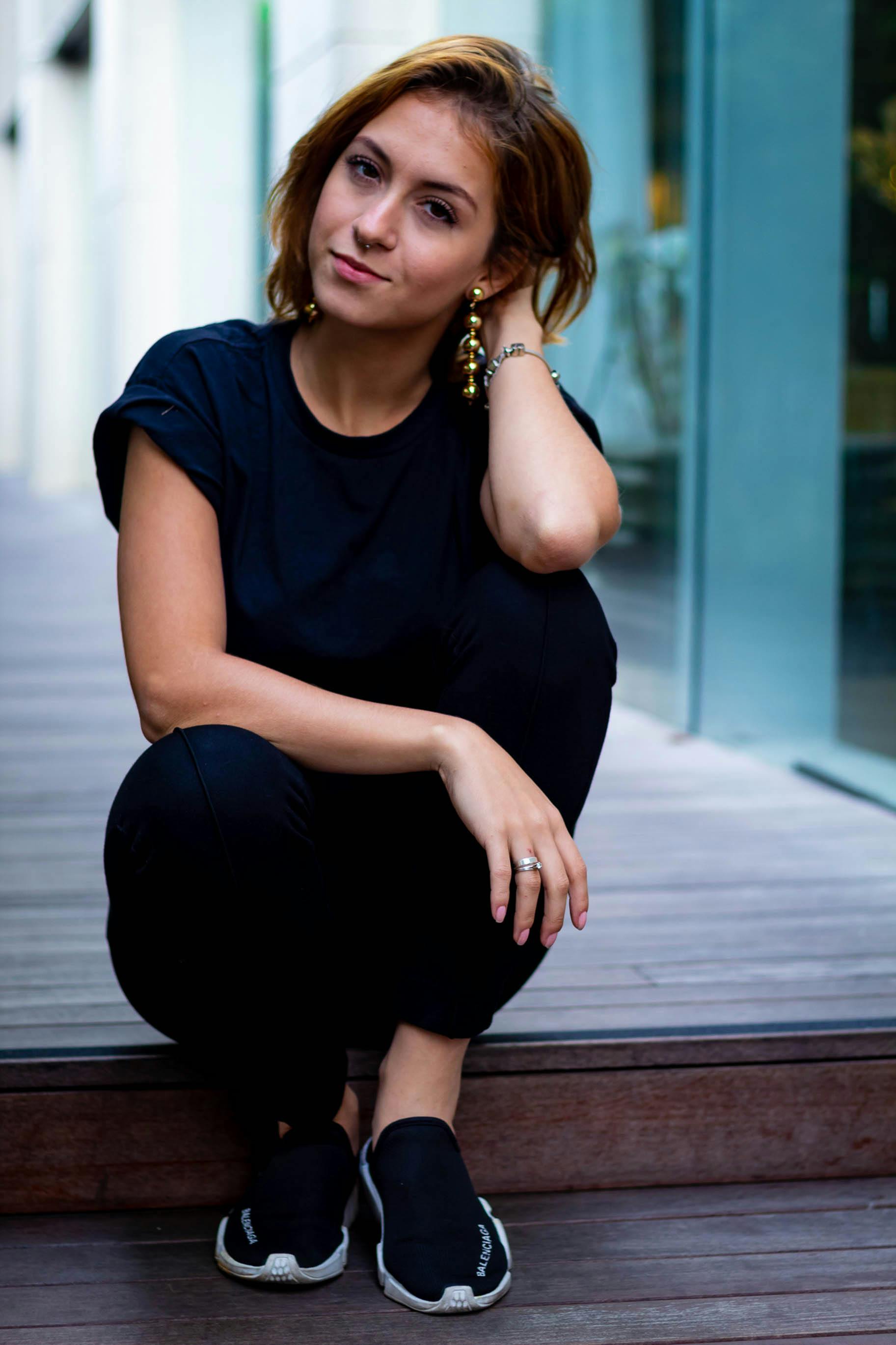 一名身着休闲装、佩戴珠宝的女子在巴西圣保罗的城市场景中摆出姿势