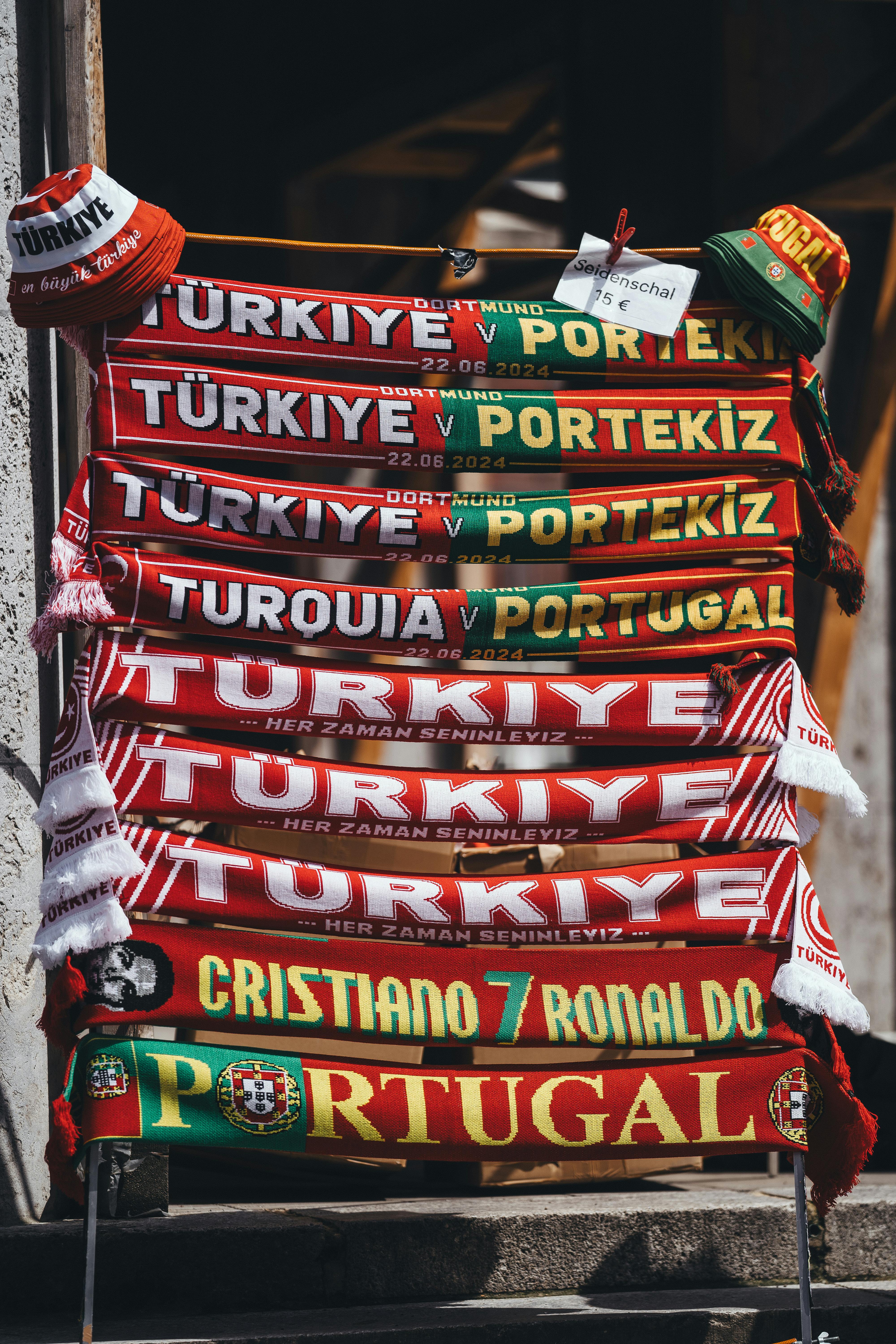 scarves from the turkey and portugal football match hanging on a rack