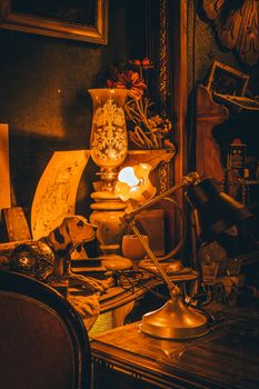 Cozy study room with vintage table lamps, antique figurine, and warm lighting ambience.