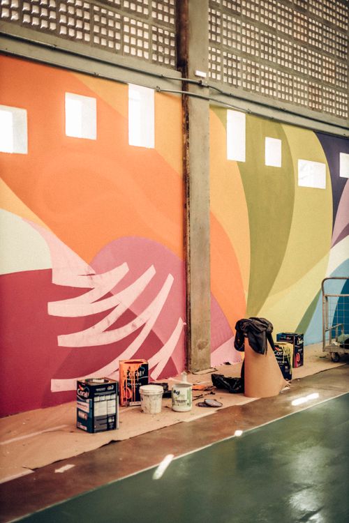 Free Colorful mural indoors with paint supplies in foreground, showcasing vibrant art. Stock Photo