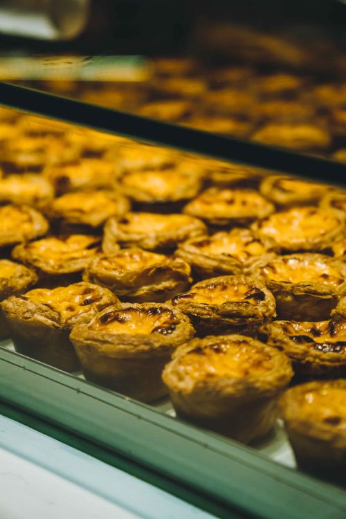Free Deliciously golden egg tarts displayed in a bakery window in Kuala Lumpur, Malaysia. Stock Photo