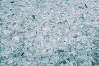 一张高细节特写，画面中是破碎散落的绿松石玻璃碎片，焦点柔和