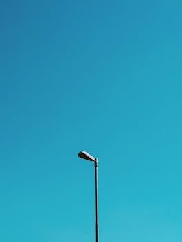 广阔的蓝天下，一盏路灯映衬出极简主义美学