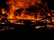 熊熊篝火的戏剧性特写，用强烈的橙色火焰照亮了漆黑的夜晚