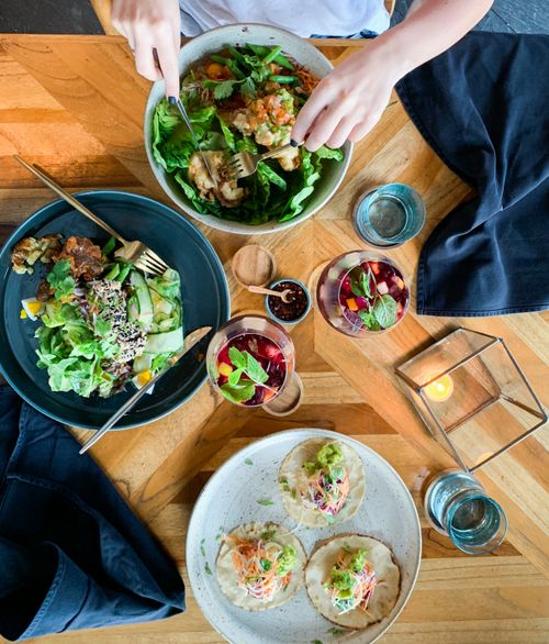 Free A colorful assortment of salads and tacos on a wooden table, perfect for a healthy meal. Stock Photo
