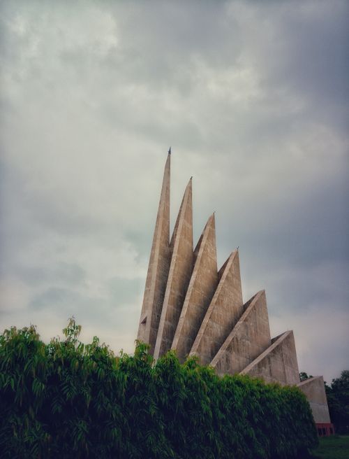 Free Iconic vertical view of the National Martyrs' Memorial against clouded sky in Savar, Bangladesh. Stock Photo