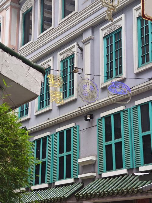 Free Vibrant tenement with neon signs and teal shutters showcasing Asian-urban architecture. Stock Photo