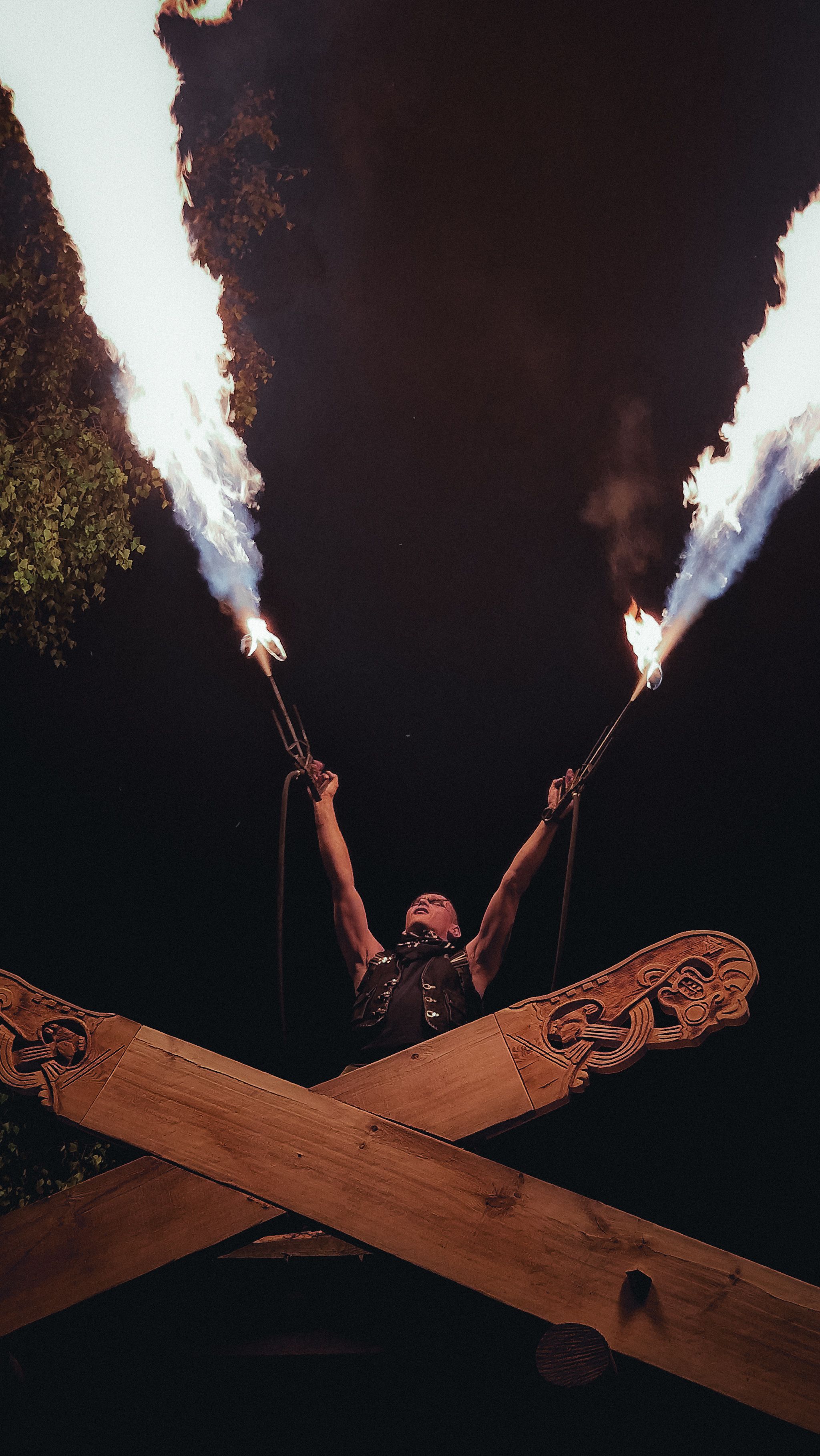 Captivating fire juggling performance at night with flames shooting into the sky above a performer.