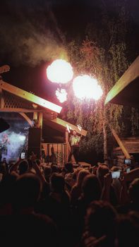 A captivating fire performance lights up the night during an outdoor music event, engaging a large audience.