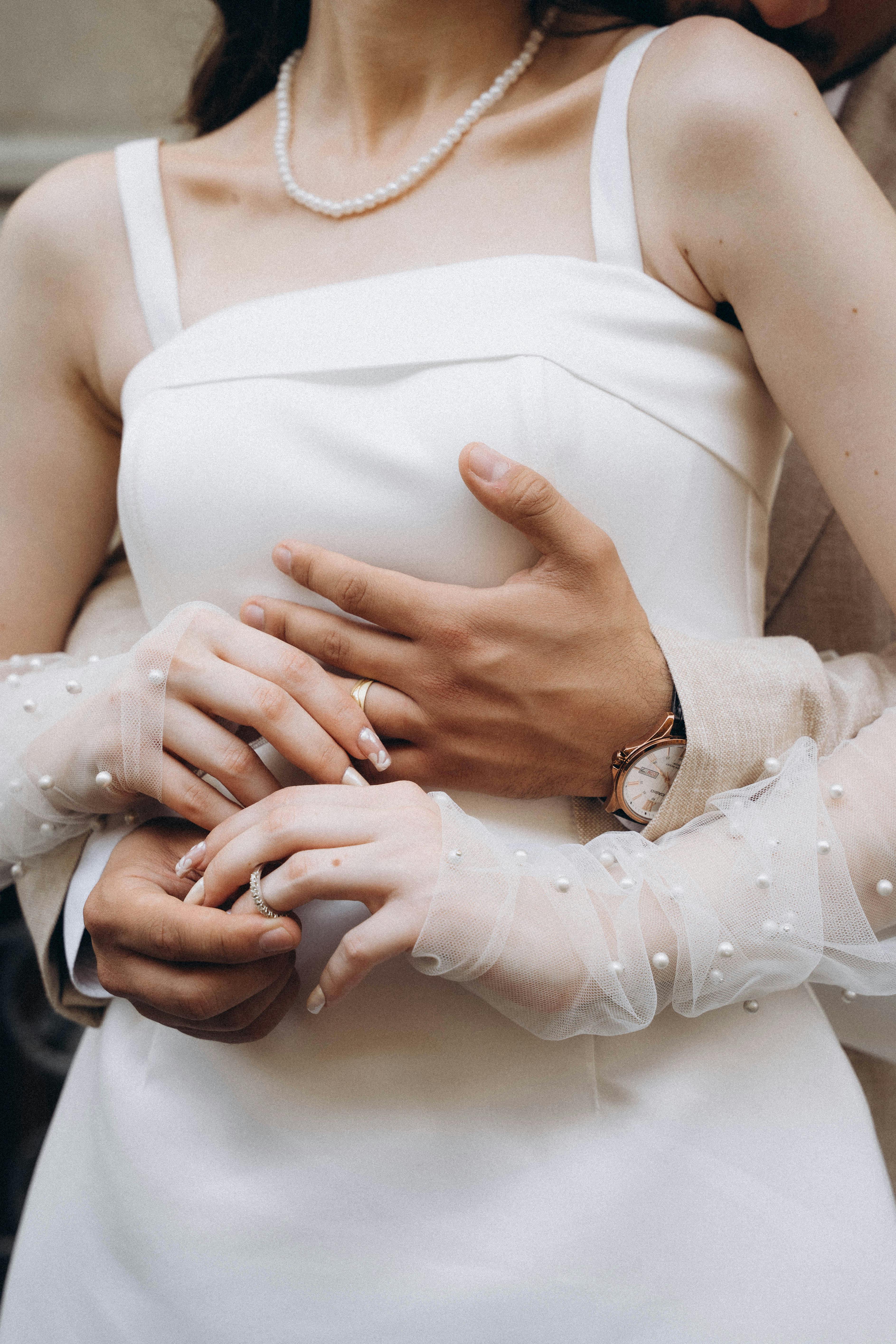 hands of groom hugging bride