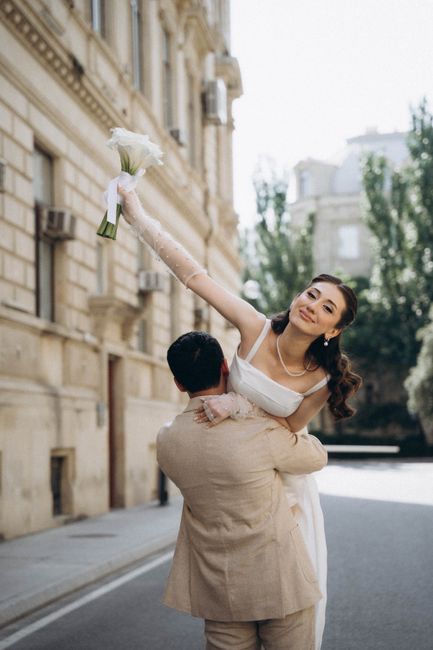 A joyful bride and groom in an elegant wedding scene on a city street.