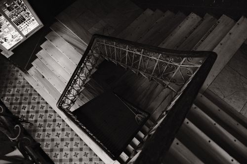 Free Artistic top view of a spiral staircase in black and white, featuring ornate railings. Stock Photo