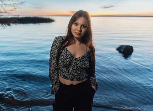 A young woman standing in front of the water