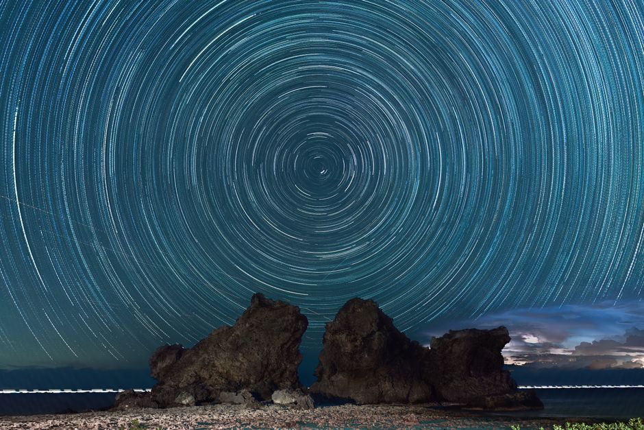 台湾の蘭嶼島にある岩の上を越える驚くべき夜空の星の軌跡。