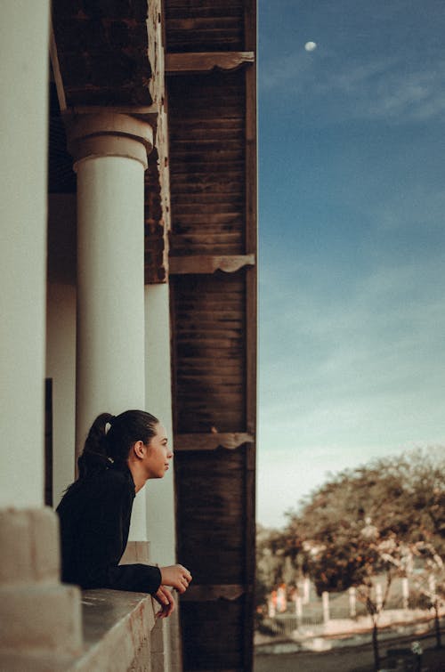 Vue Latérale Photo De Femme Appuyée Sur Une Balustrade En Pierre à La Recherche Au Loin