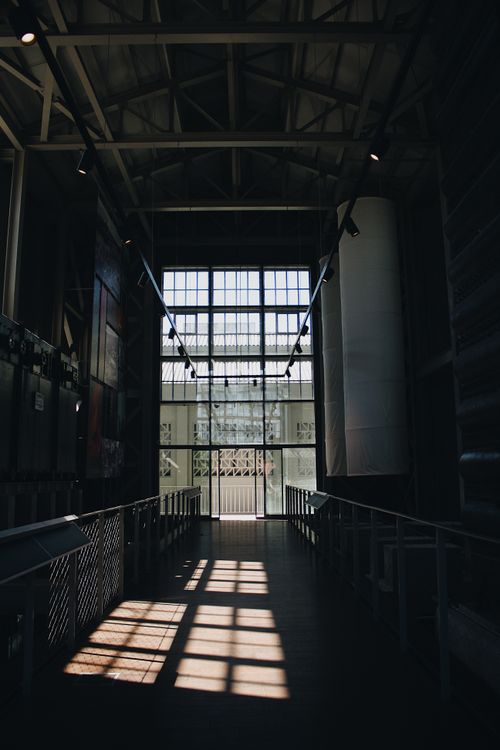 Free Interior of industrial hallway with dramatic light and shadow play from large windows. Stock Photo