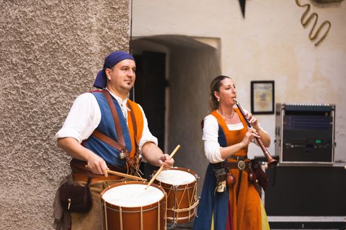 Free Street musicians perform with drums and flutes in traditional attire, creating a vibrant cultural scene. Stock Photo