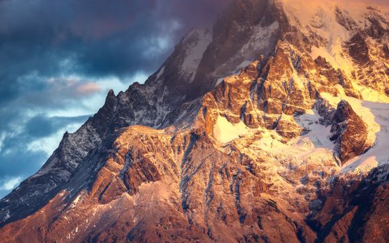 Captivating view of sunrise over rugged Torres del Paine in Patagonia with snow-capped peaks.
