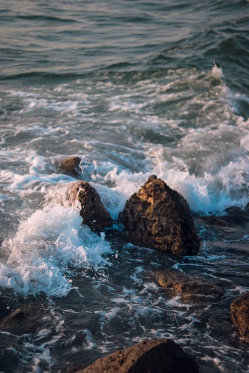 Free Dynamic shot of waves crashing against rocks on the coast of Sharjah, UAE's serene seascape. Stock Photo