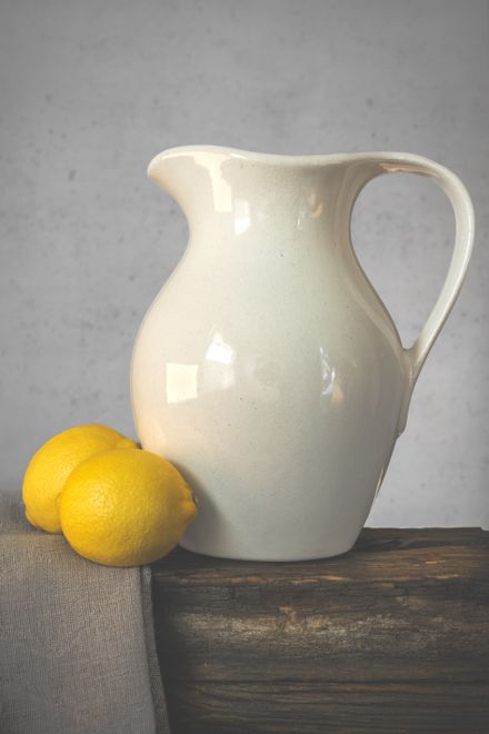 Still life of a cream ceramic jug beside lemons — photo by Ylanite Koppens on Pexels