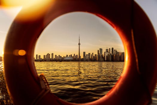 Beautiful view of Toronto skyline through a lifebuoy, highlighting CN Tower at sunset.