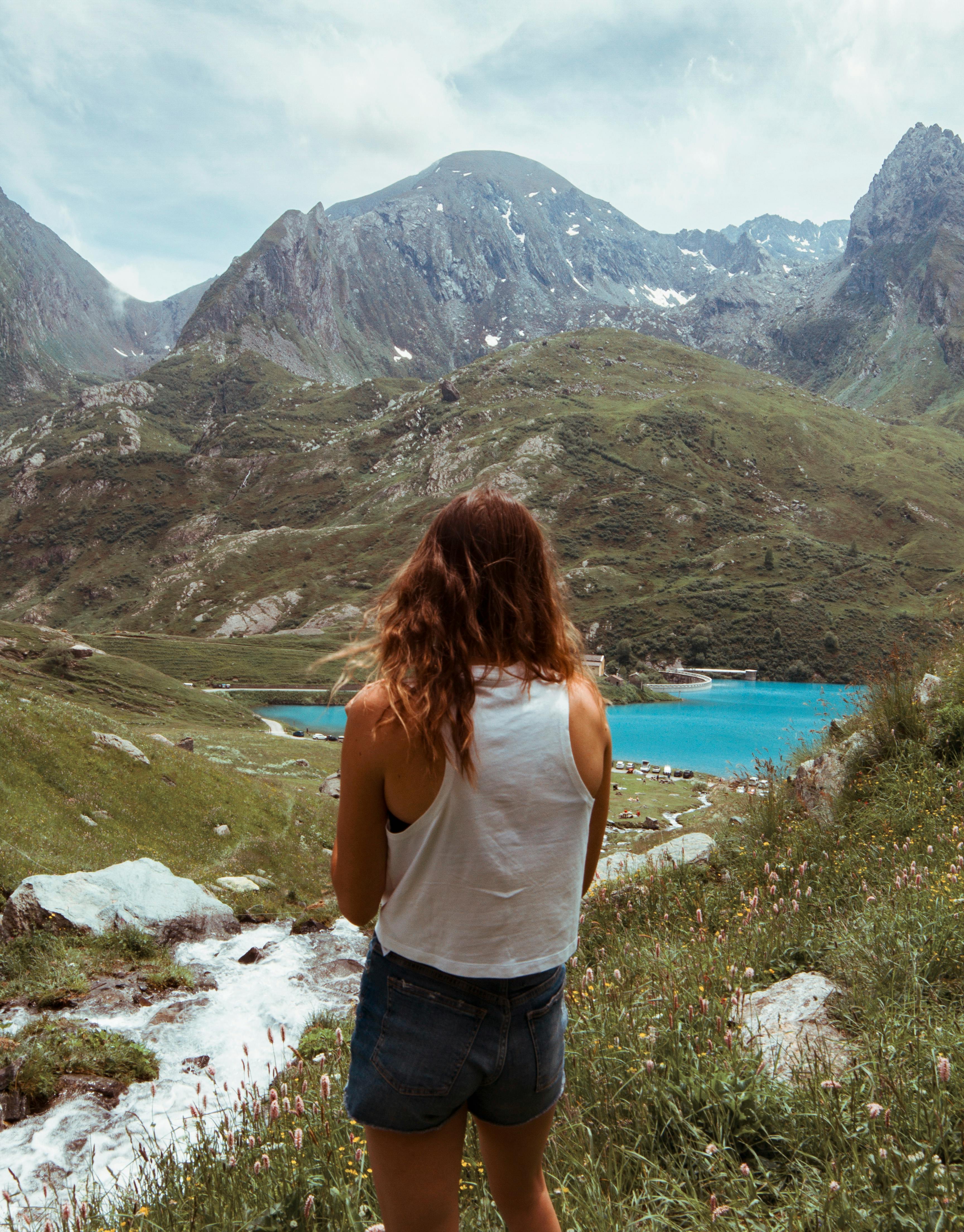 Woman enjoying breathtaking mountain view over an alpine lake in Piedmont, Italy.