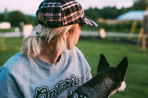 Close-Up Photo of Person Carrying a Dog