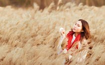 Woman Standing in the Middle of Brown Hay Field