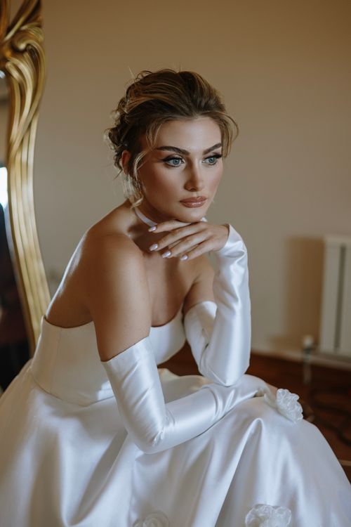 Free Beautiful bride in Istanbul, captured in an elegant strapless wedding gown with a thoughtful pose. Stock Photo