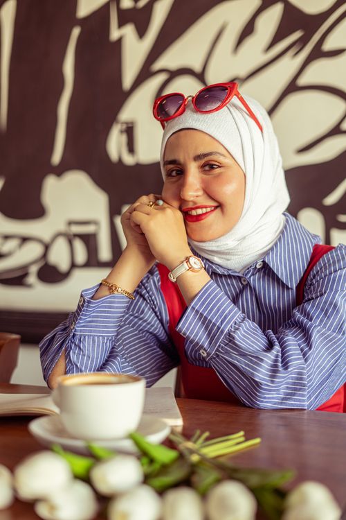 Free Middle Eastern woman in a headscarf smiling with coffee at a café in Baghdad, Iraq. Stock Photo