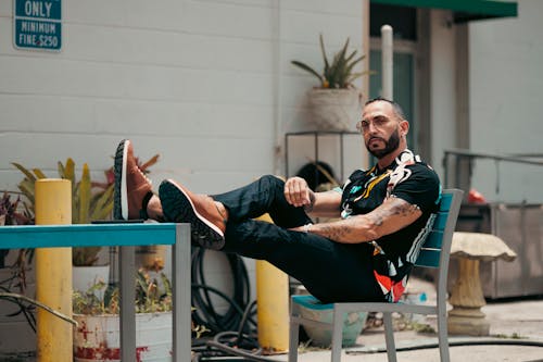 A man sitting on a chair in front of a building