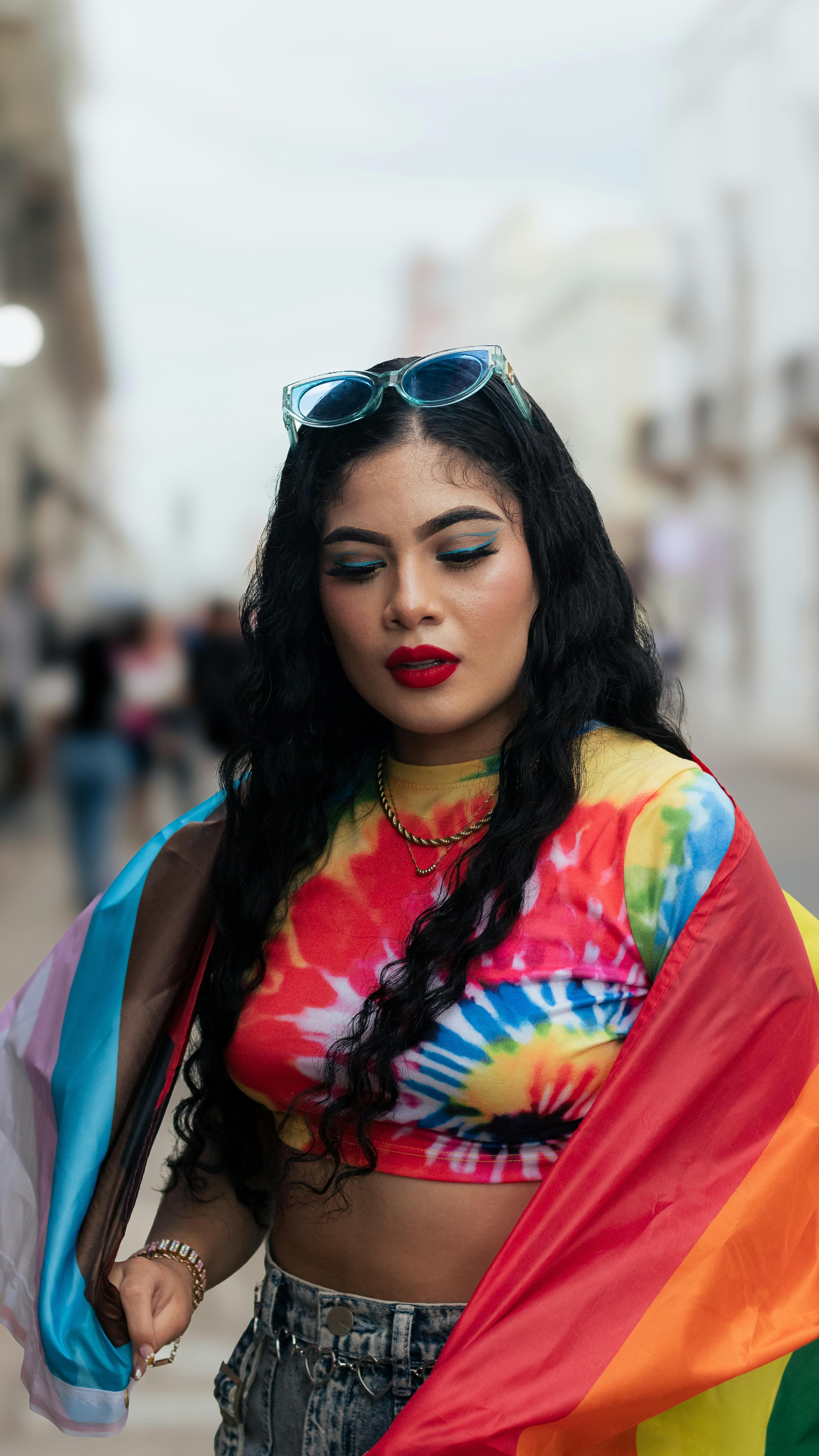 A woman in a rainbow colored top and sunglasses · Free Stock Photo