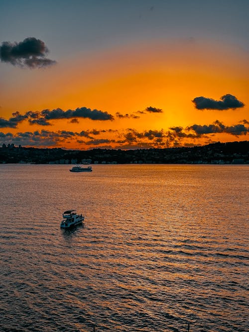 A boat is floating in the water at sunset