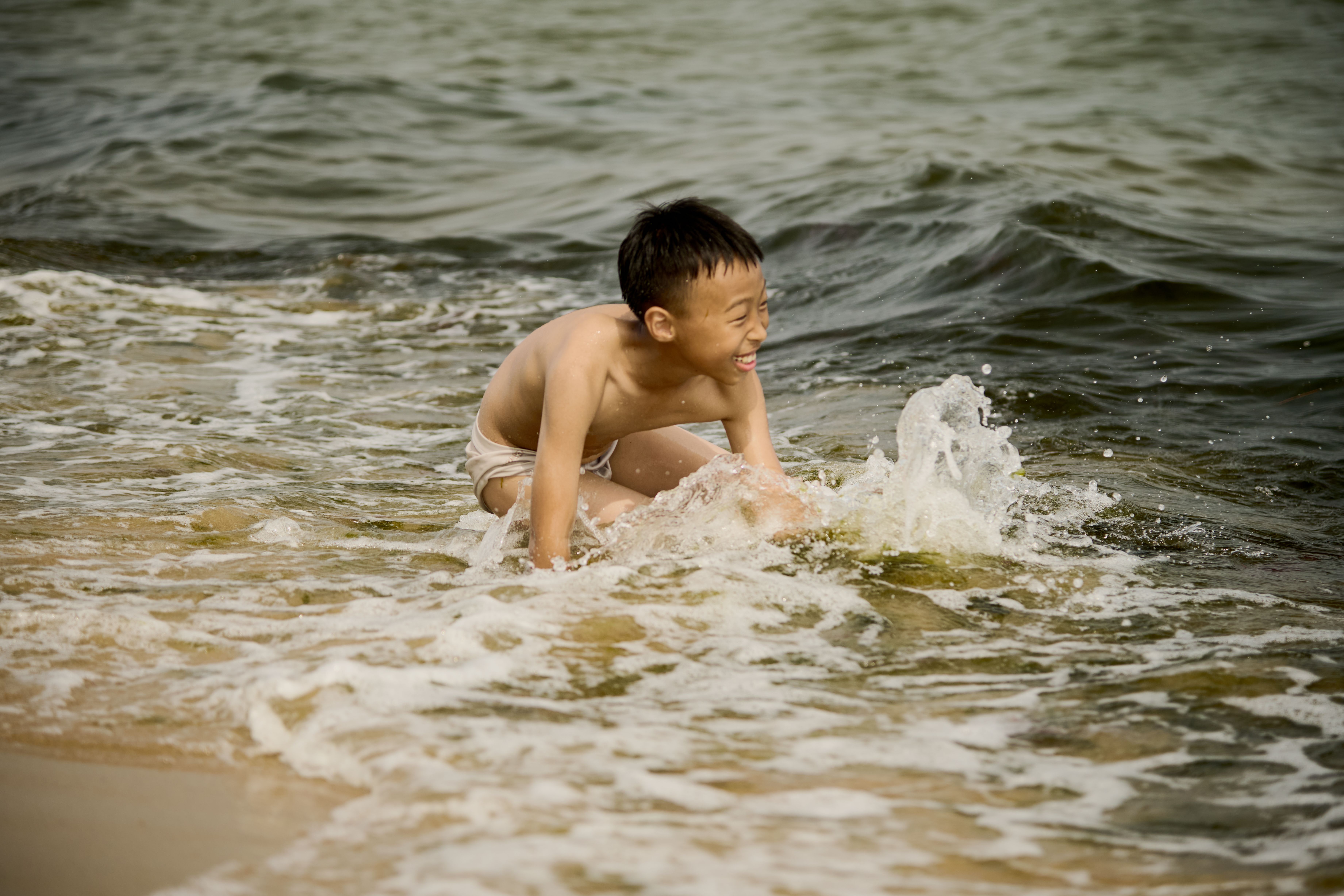 A boy playing in the ocean waves · Free Stock Photo