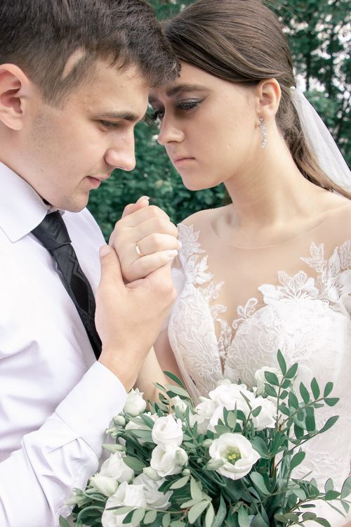 Couple holding hands with a bridal bouquet