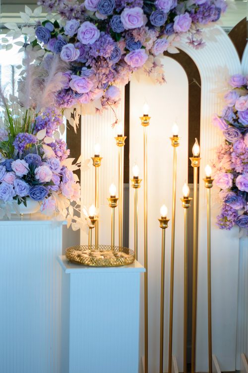 Free Lavish floral arrangement with purple flowers and golden candles for weddings. Stock Photo
