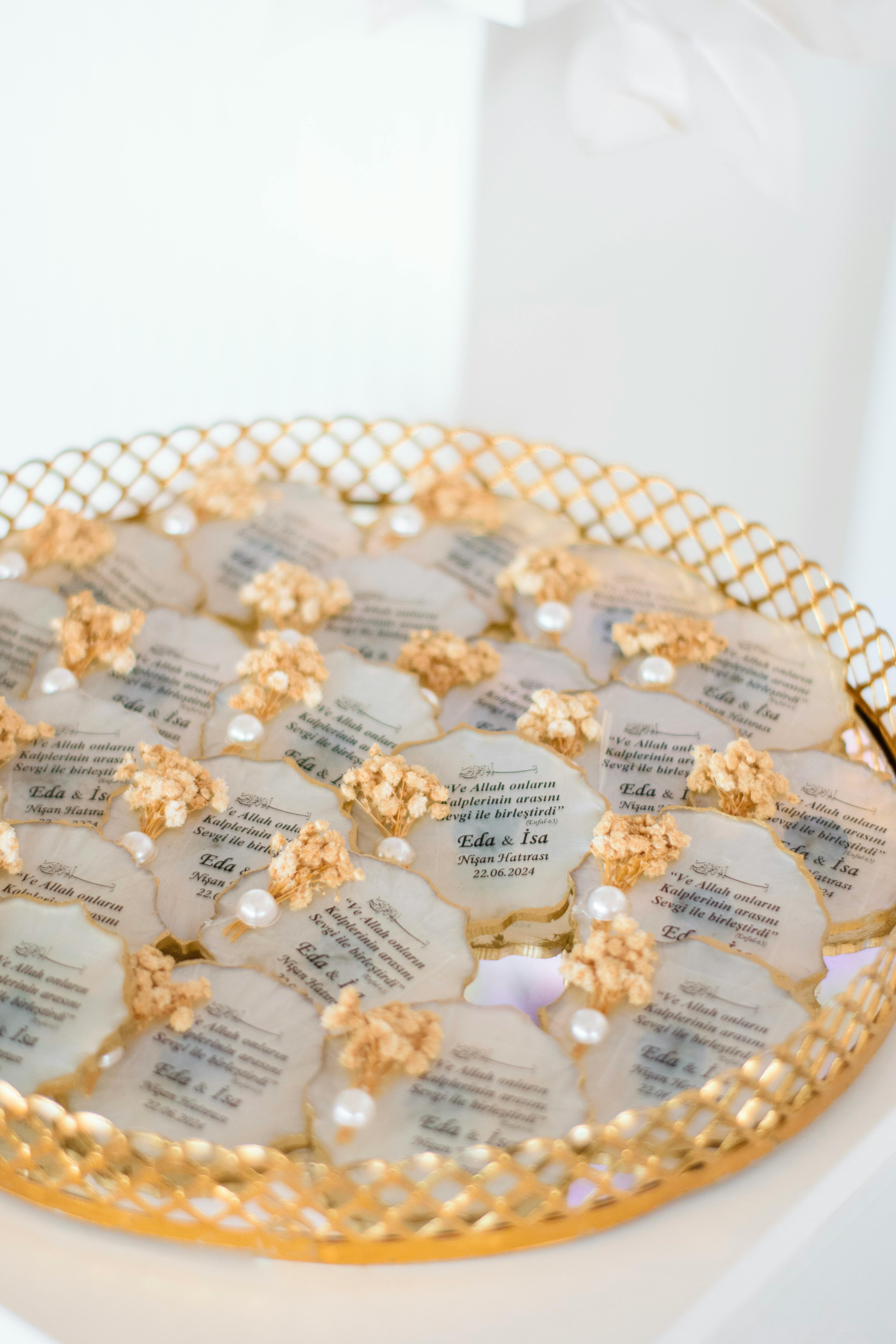 Sophisticated golden trays featuring decorative wedding invitations with pearls and floral accents.