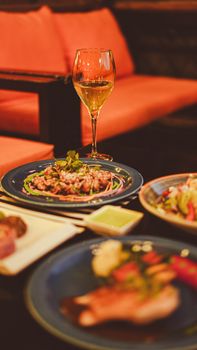 Sophisticated dinner featuring white wine and gourmet dishes in a cozy restaurant setting.