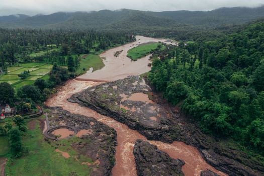 Drone shot of Kakarda river and forest landscape in monsoon season, vibrant and lush greenery.