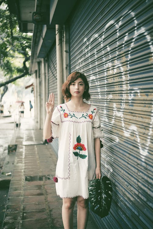 Photo of Woman Standing Near Roller Shutter