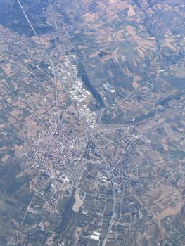 High-angle aerial shot capturing vast fields and towns, showcasing rural landscape patterns.