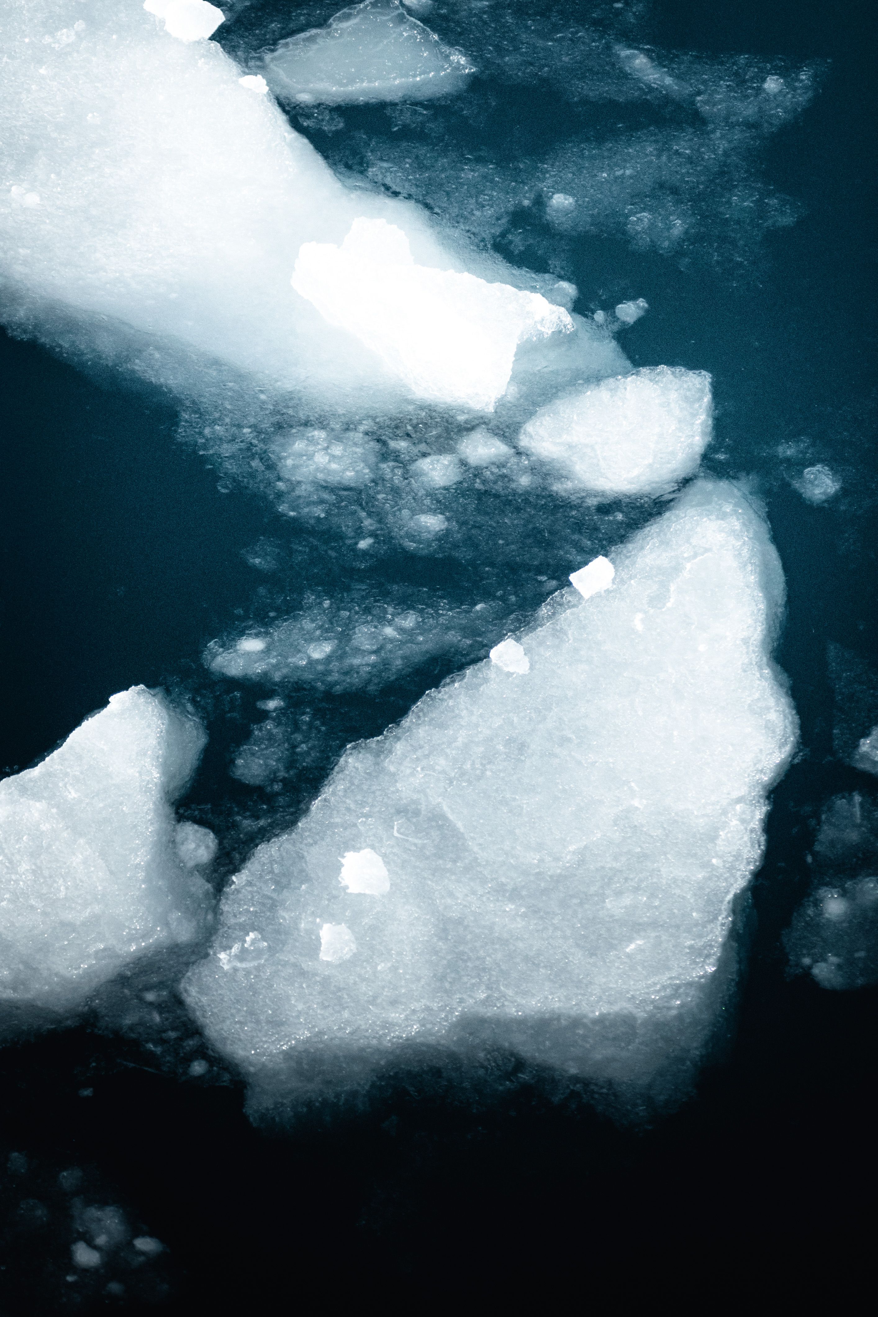 Fotomural Flujos de hielo congelado a la deriva en el frío mar polar, capturados en una toma vertical.