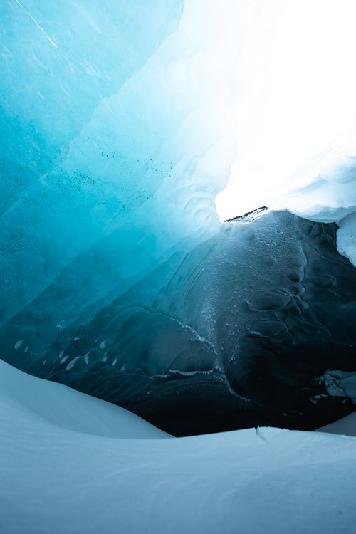 Free An awe-inspiring view inside a natural ice cave reveals vibrant blue hues with intricate textures. Stock Photo