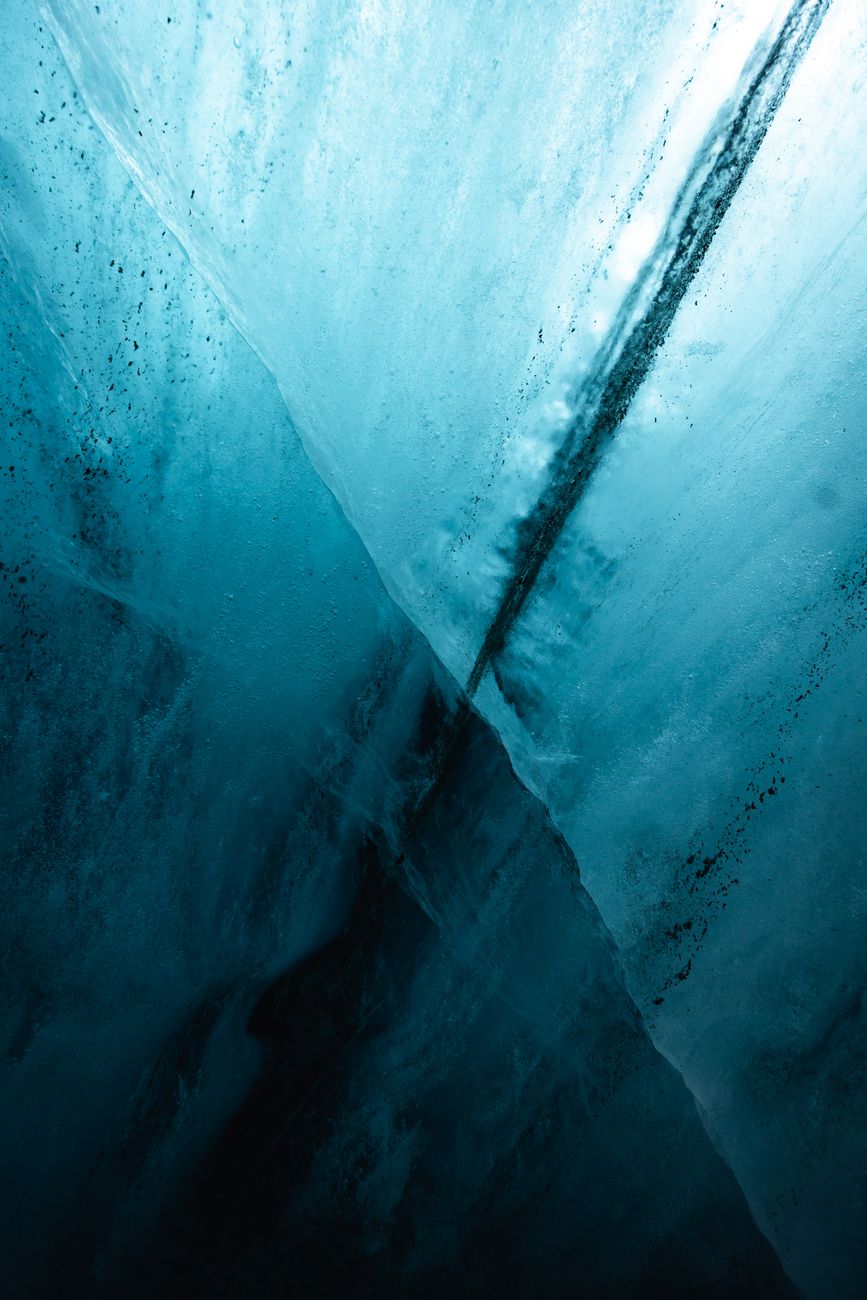 Abstract view of ice with deep cracks showcasing blue tones and textures.. abstract, view, with