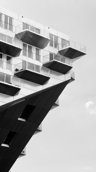 Striking modern building facade with balconies in a black and white urban setting.